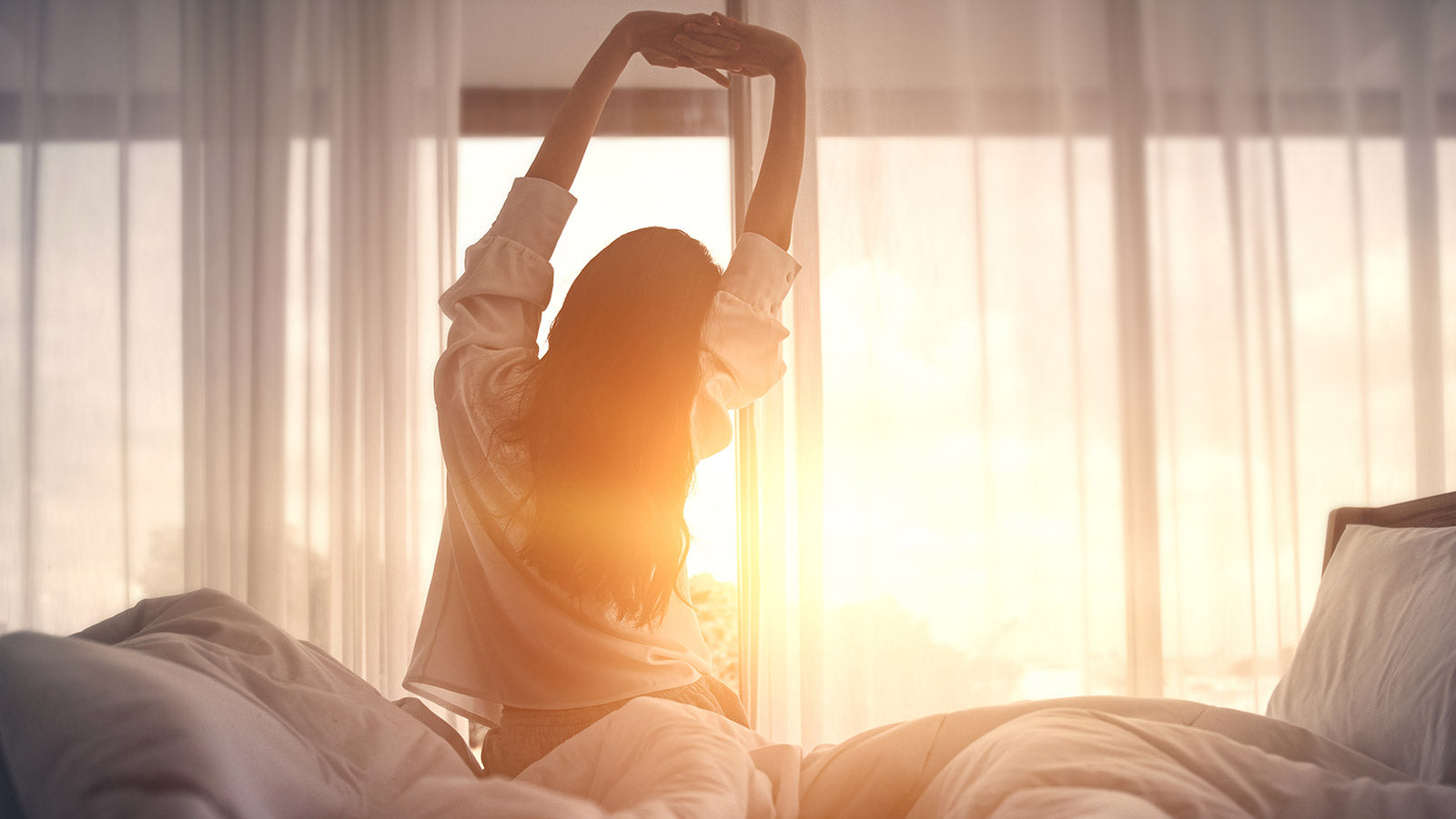 Woman stretching after a good night of sleep from taking CBD.