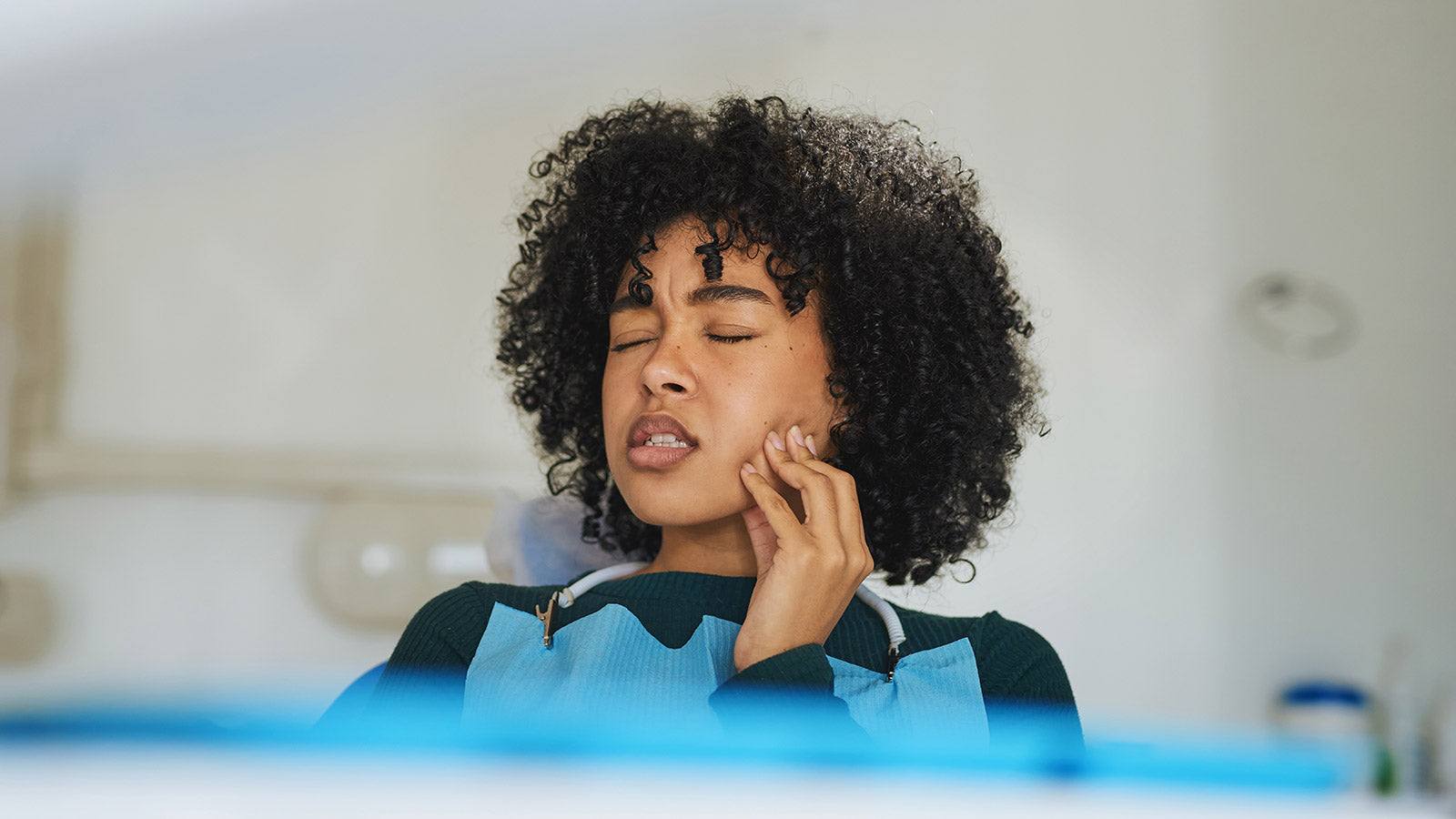 Woman with sore jaw, who is learning how to stop grinding her teeth in her sleep naturally.
