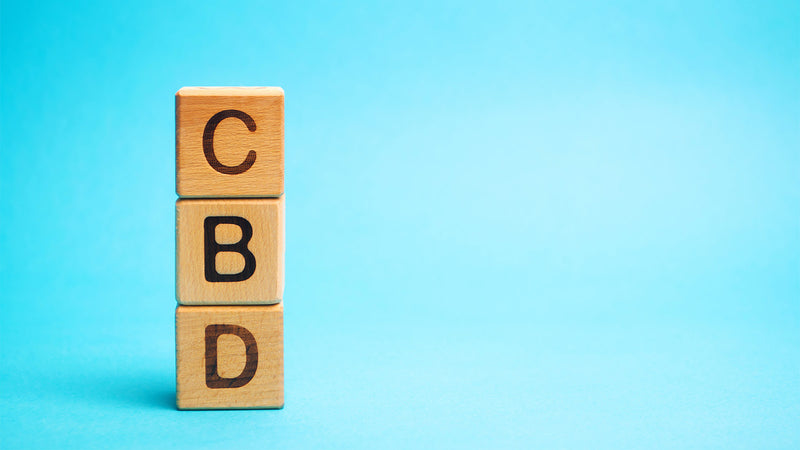 CBD spelled out in wooden building blocks stacked on top of each other