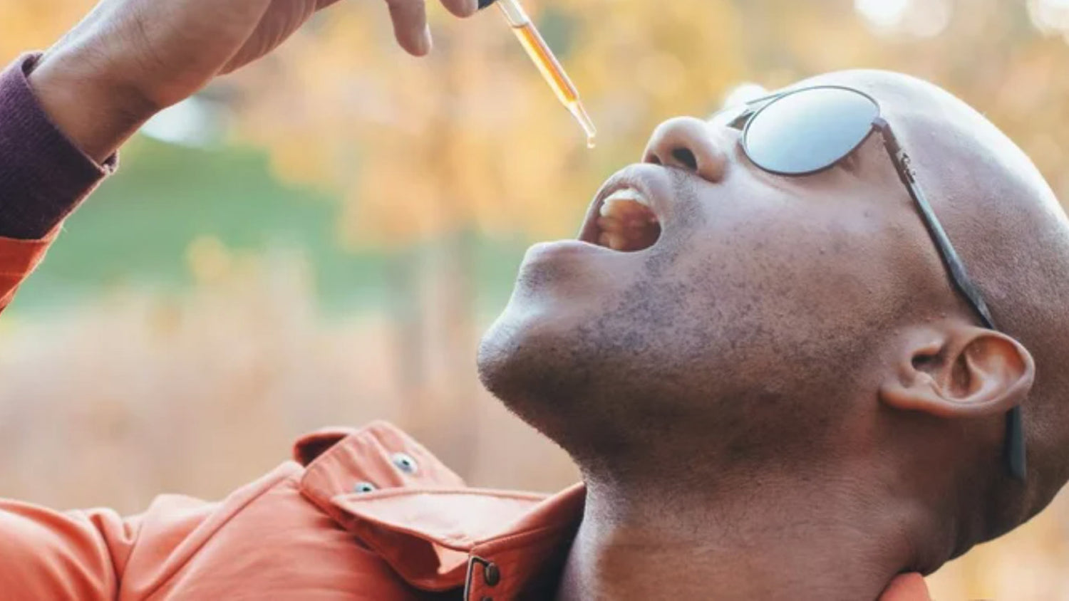 Man taking a tincture outdoors