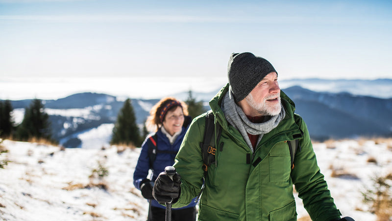 Older couple out hiking and enjoying a healthy active lifestyle with the tips we've provided.