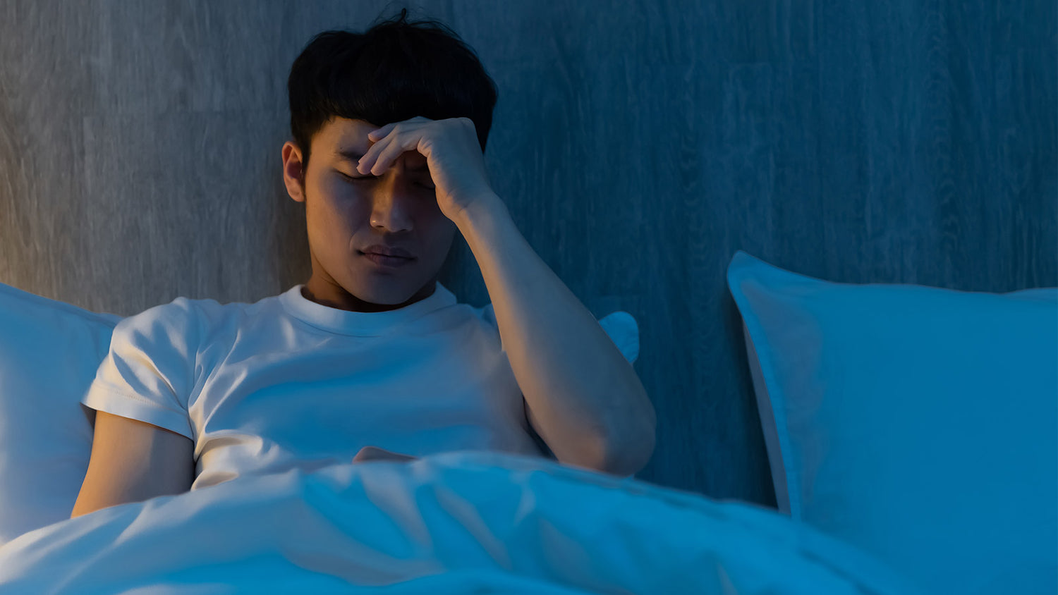 Man struggling to sleep at night and asking himself 'why can't I sleep?'